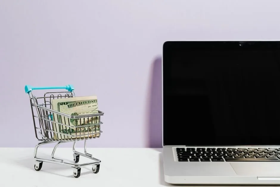 Emprendedor digital analizando gráficos de proyecciones financieras para un ecommerce en su ordenador para evitar problemas de liquidez.