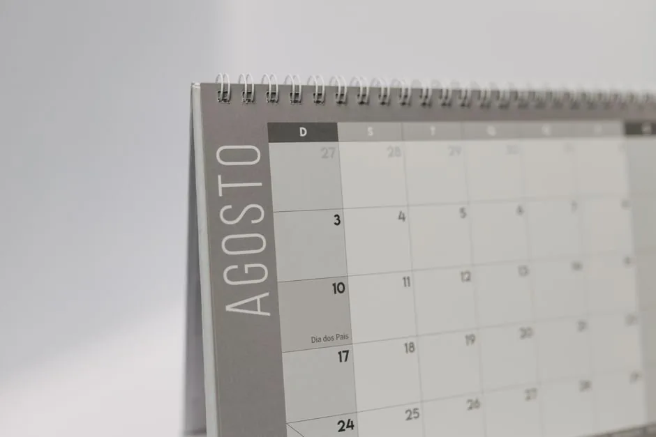Calendario fiscal de agosto sobre un escritorio mostrando plazos de impuestos de la AEAT para vendedores de comercio electrónico.