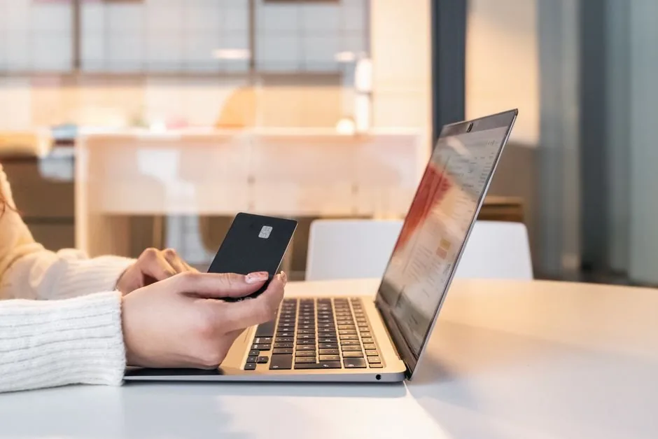Emprendedor digital revisando facturas y modelos de impuestos trimestrales de su tienda online en su ordenador portátil