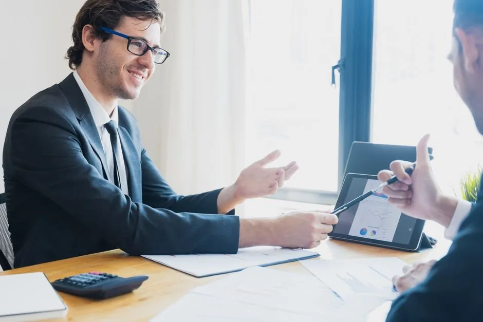 Consultor financiero analizando gráficos de rentabilidad en una pantalla para ayudar a un empresario de ecommerce a tomar decisiones.